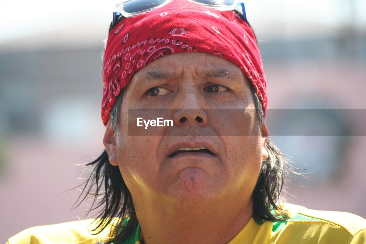 Close-up of mature man wearing red bandana on sunny day