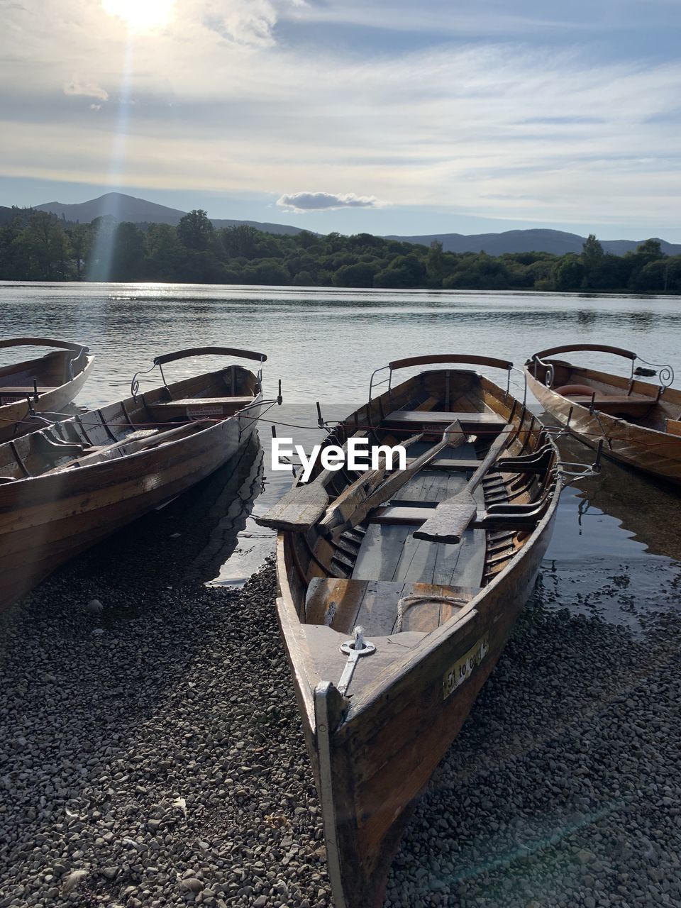 BOATS MOORED AT LAKE AGAINST SKY