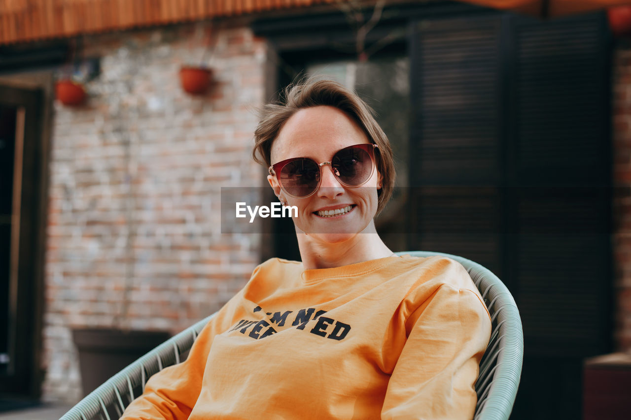 PORTRAIT OF HAPPY MAN WEARING SUNGLASSES