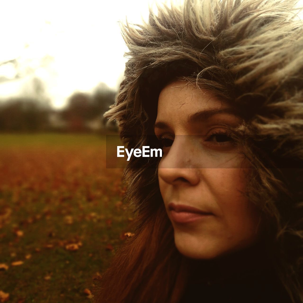 Close-up of thoughtful mid adult woman wearing warm clothing in park during autumn