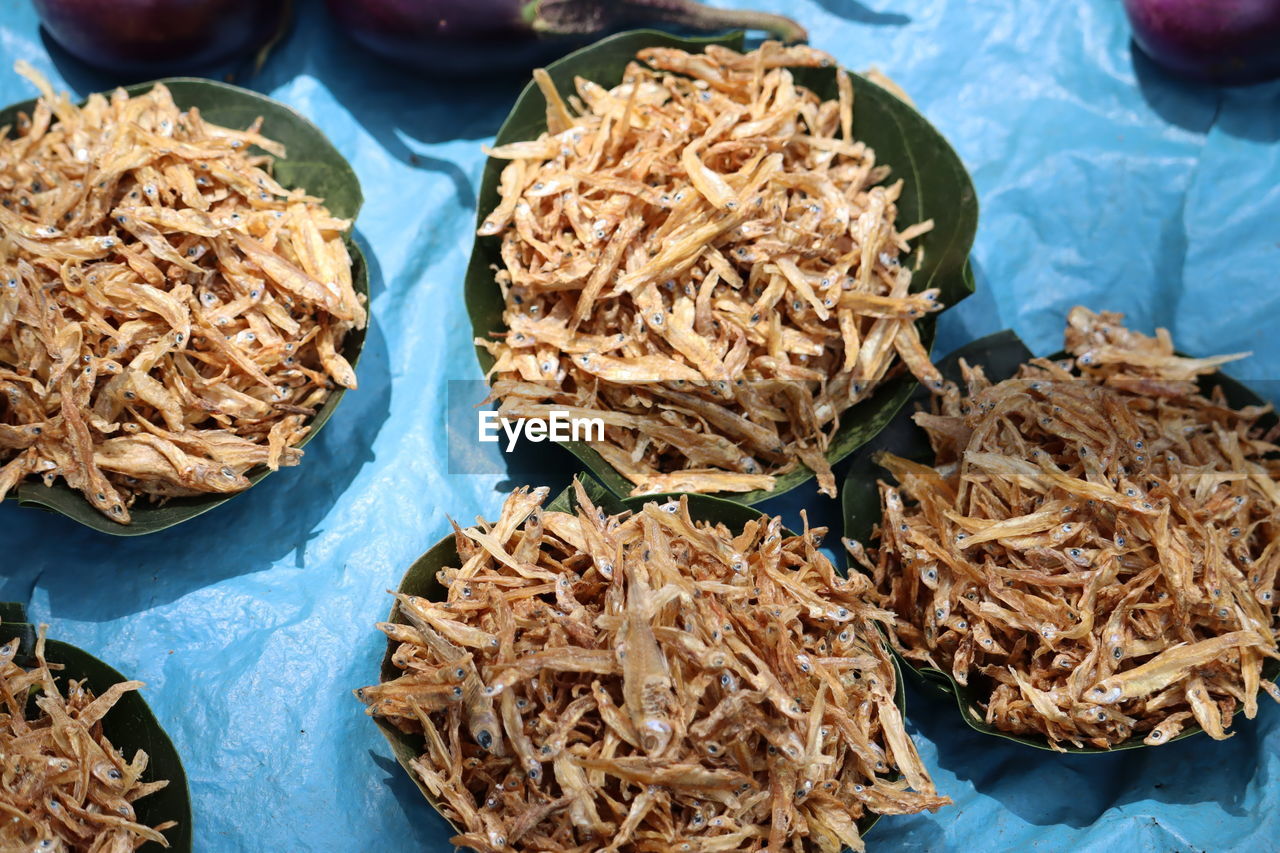 Bucket of dry fish in leaves 