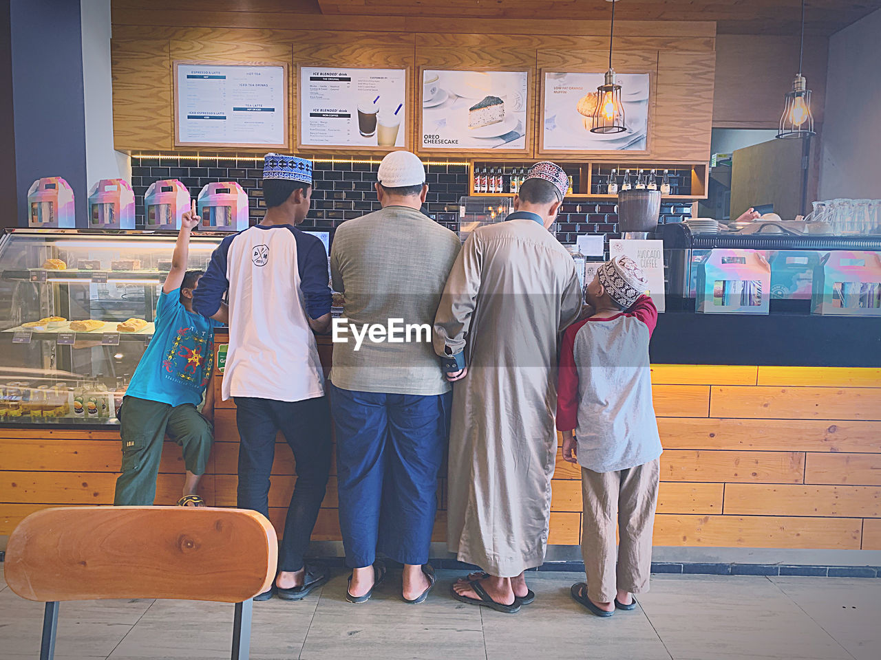 REAR VIEW OF PEOPLE STANDING AGAINST THE WALL IN A ROW