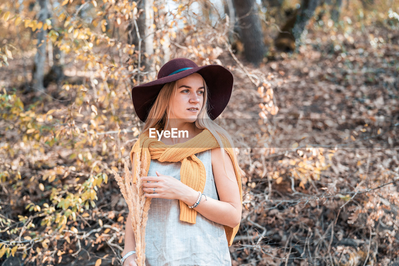 Young woman wearing hat standing on land