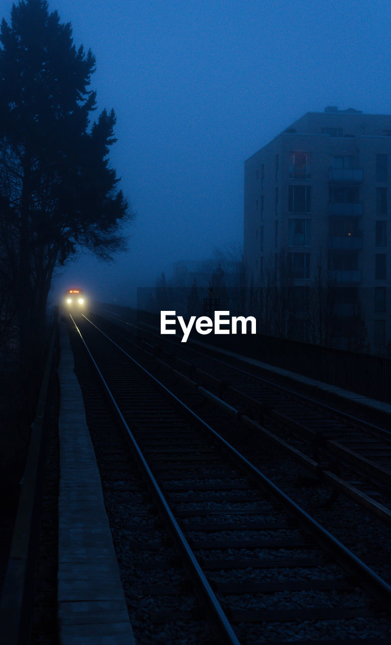 RAILROAD TRACK AGAINST SKY AT NIGHT