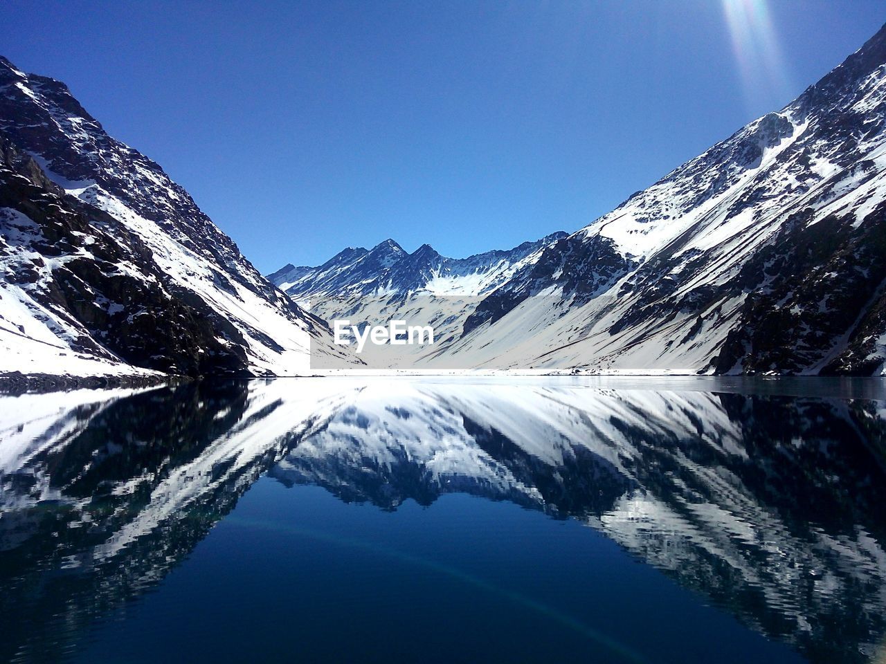 Scenic view of snowcapped mountains against clear blue sky