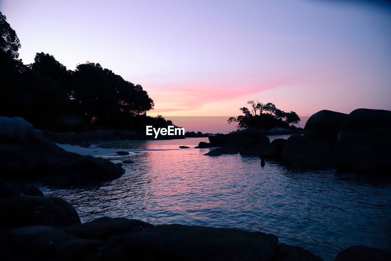 SILHOUETTE ROCKS ON SEA AGAINST SKY AT SUNSET