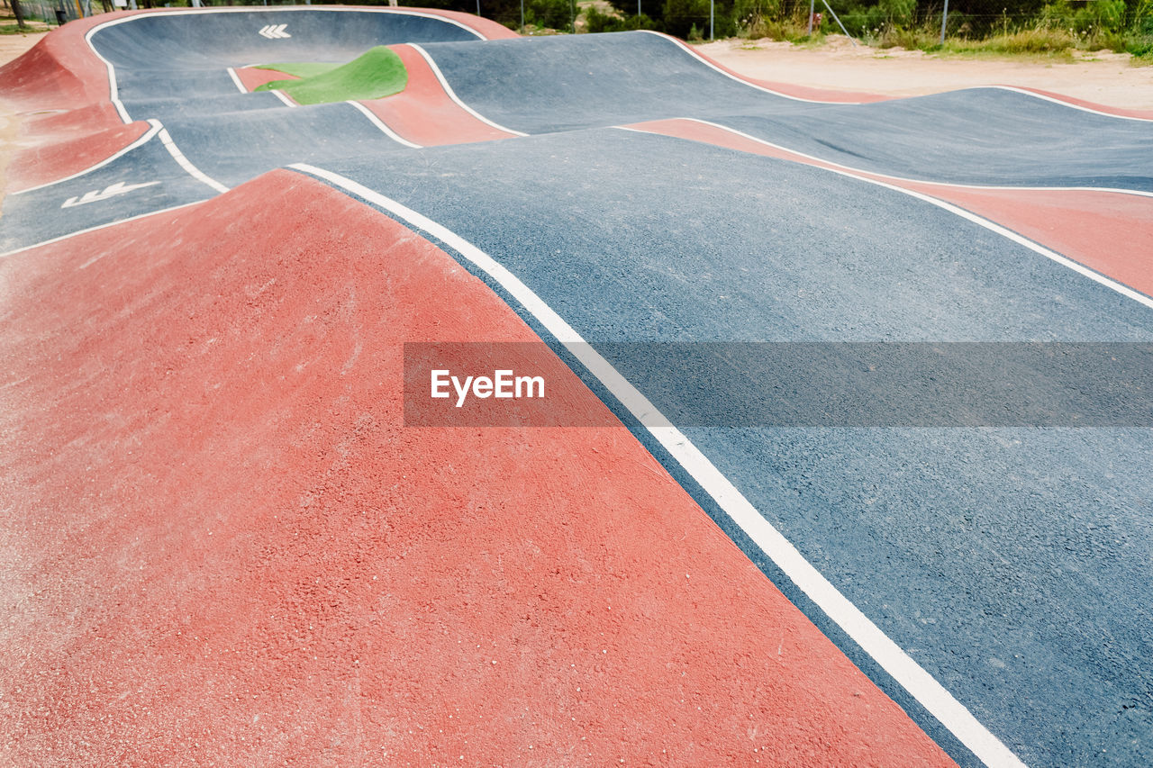 Wavy pump track circuit for skaters with lanes and arrows indicating directions