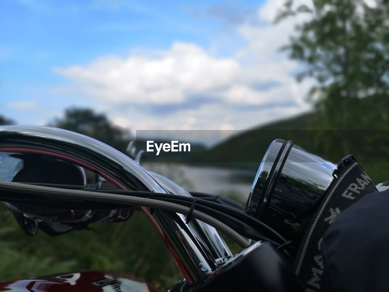 CLOSE-UP OF MOTORCYCLE ON ROAD AGAINST SKY