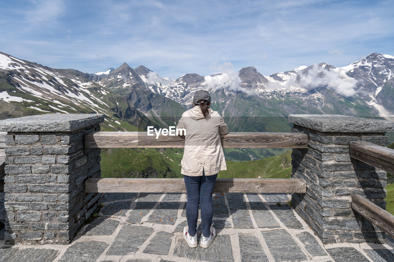 Rear view of woman looking at snowcapped mountain against sky