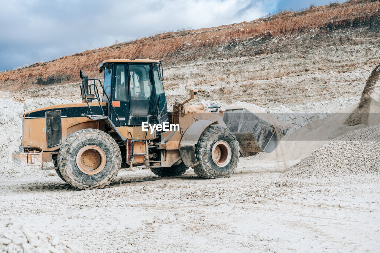 Wheel loader with large bucket on construction site or quarry. mining heavy machinery details. 