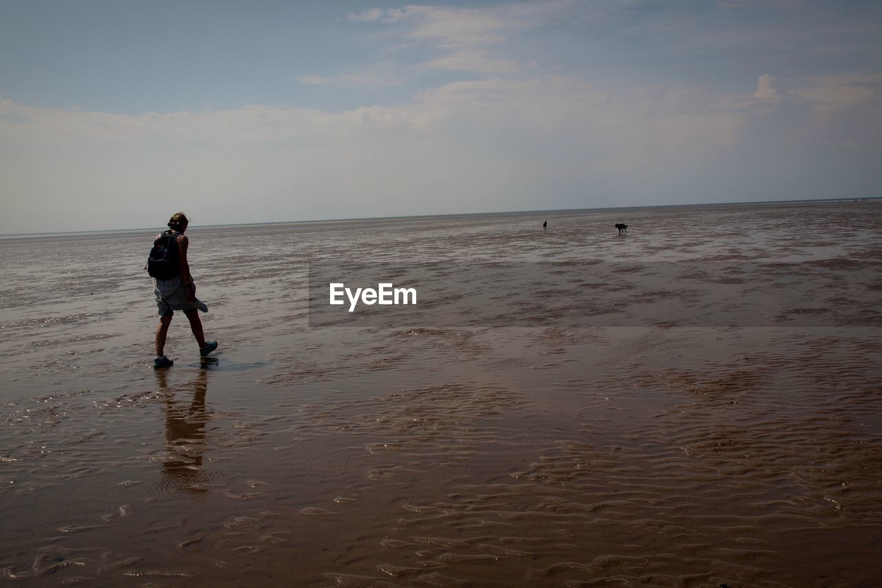 Full length of woman on beach against sky