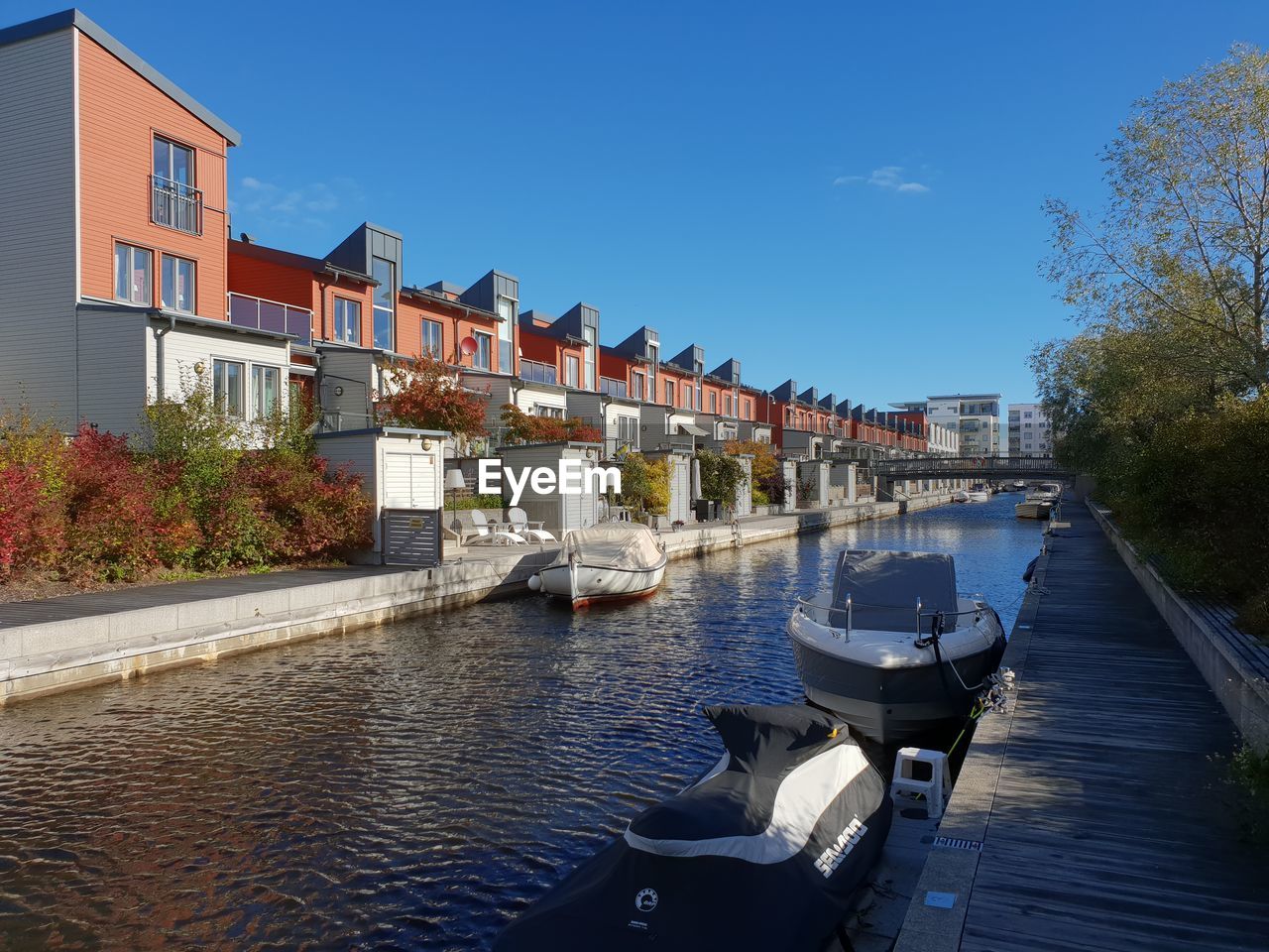 Boats moored in canal amidst buildings against sky