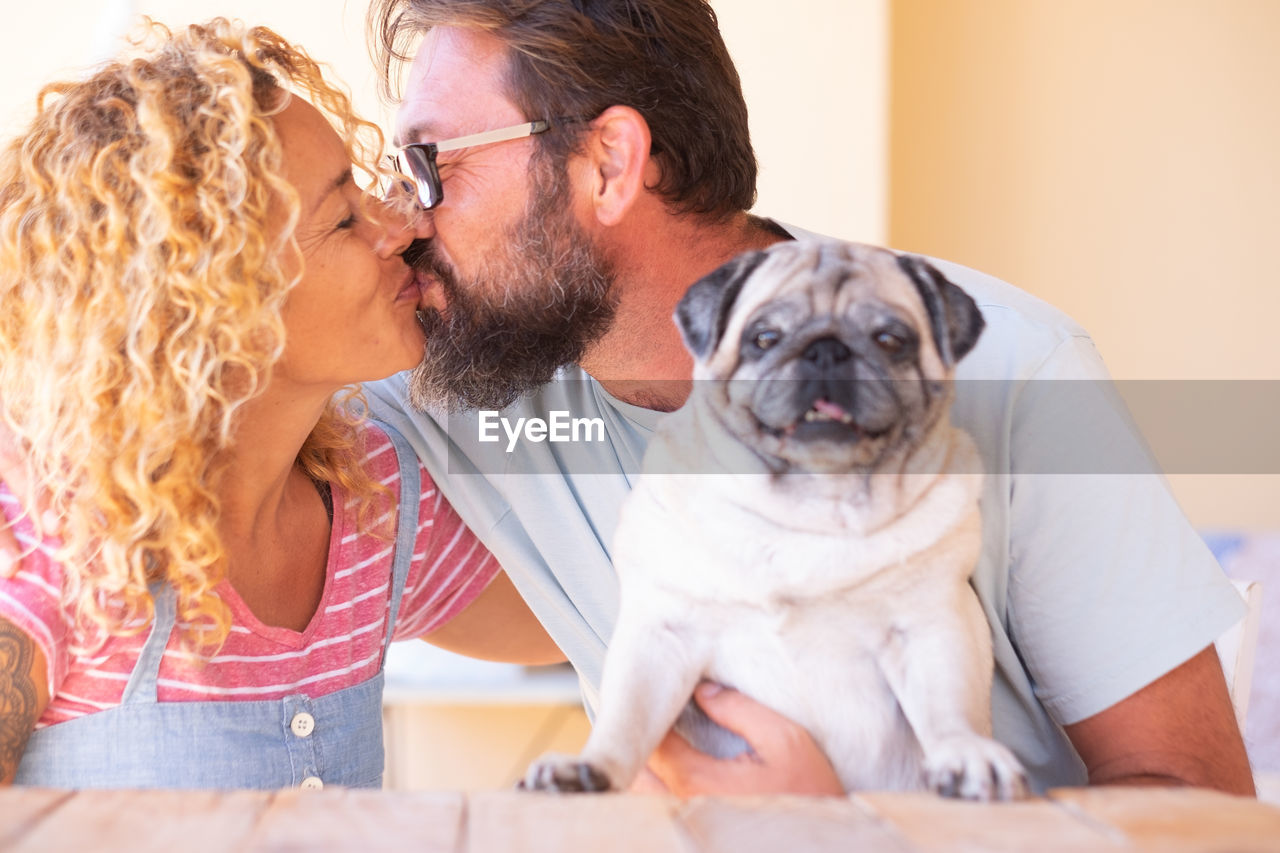 PORTRAIT OF COUPLE WITH DOG SITTING ON FLOOR