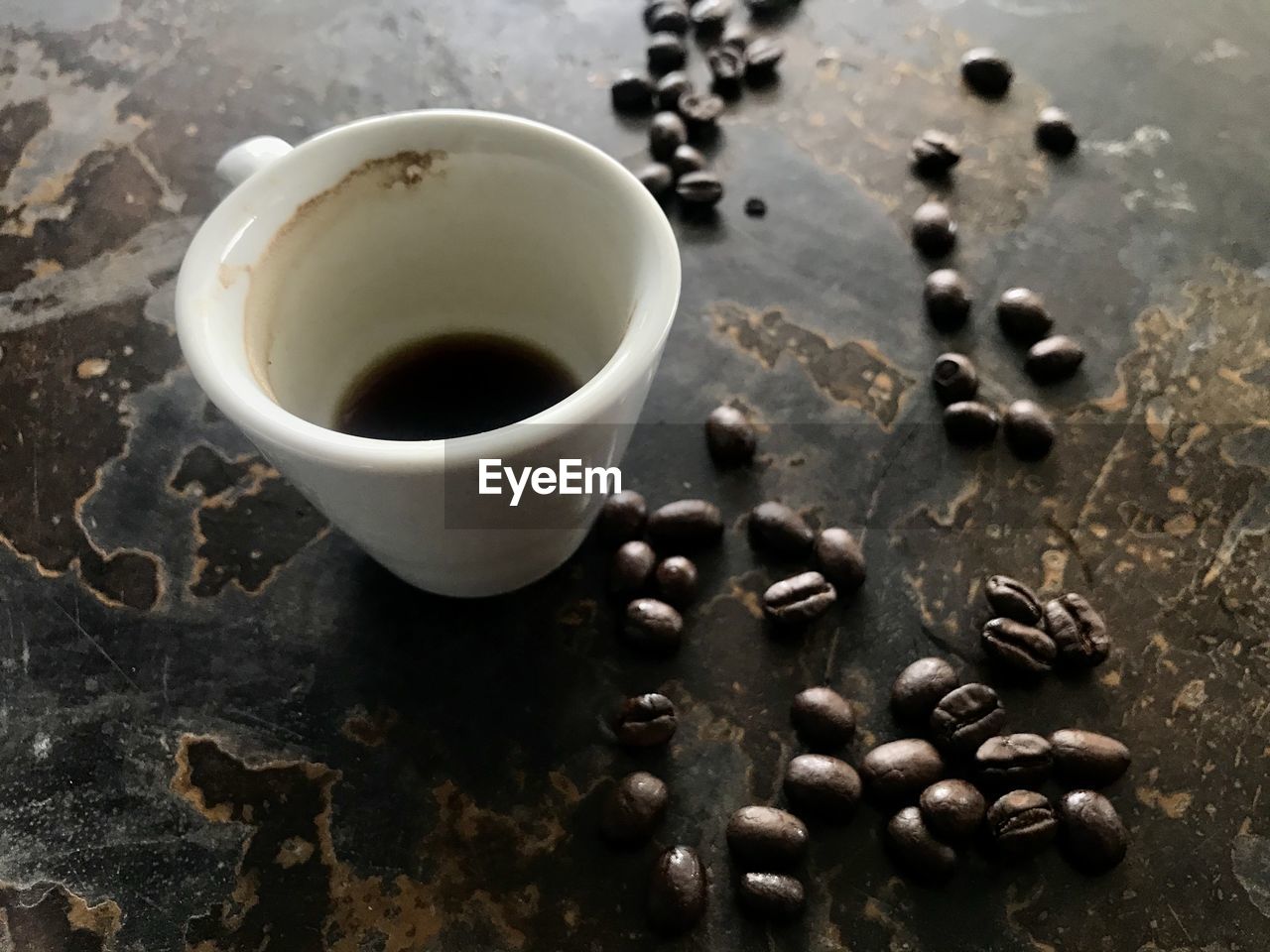 HIGH ANGLE VIEW OF COFFEE CUP ON TABLE WITH BLACK BACKGROUND