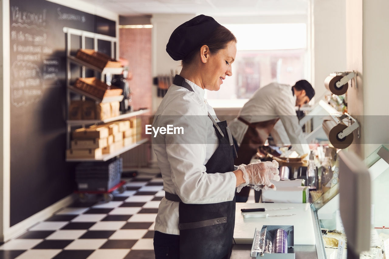 Side view of owners working at counter in grocery store