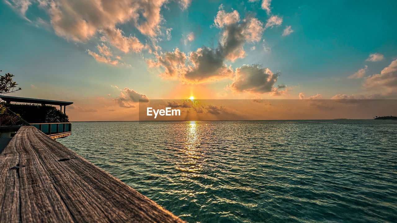scenic view of sea against cloudy sky during sunset