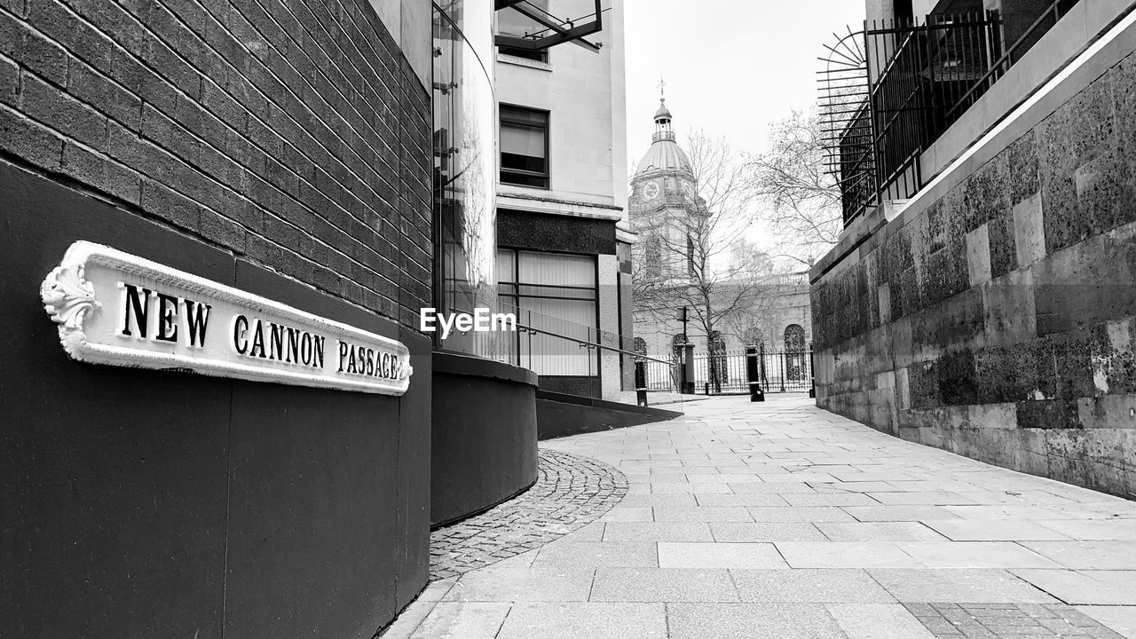 INFORMATION SIGN ON STREET AMIDST BUILDINGS