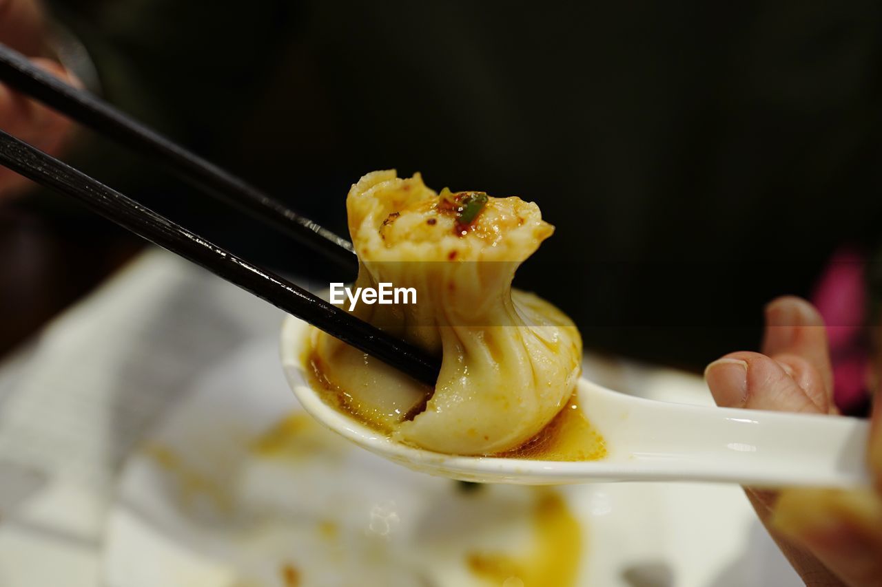 Cropped image of person holding dumpling at restaurant