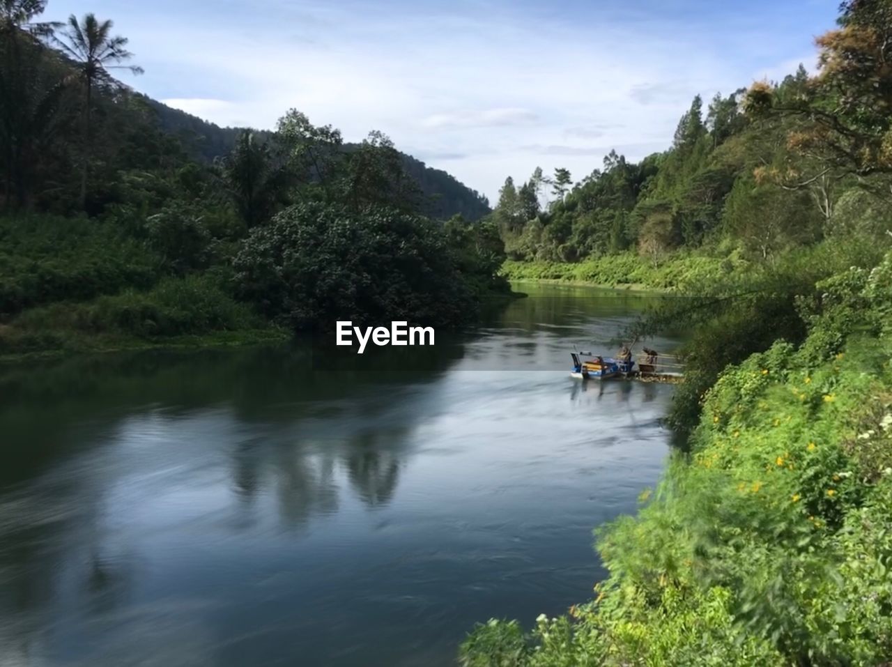 PEOPLE IN RIVER AGAINST SKY