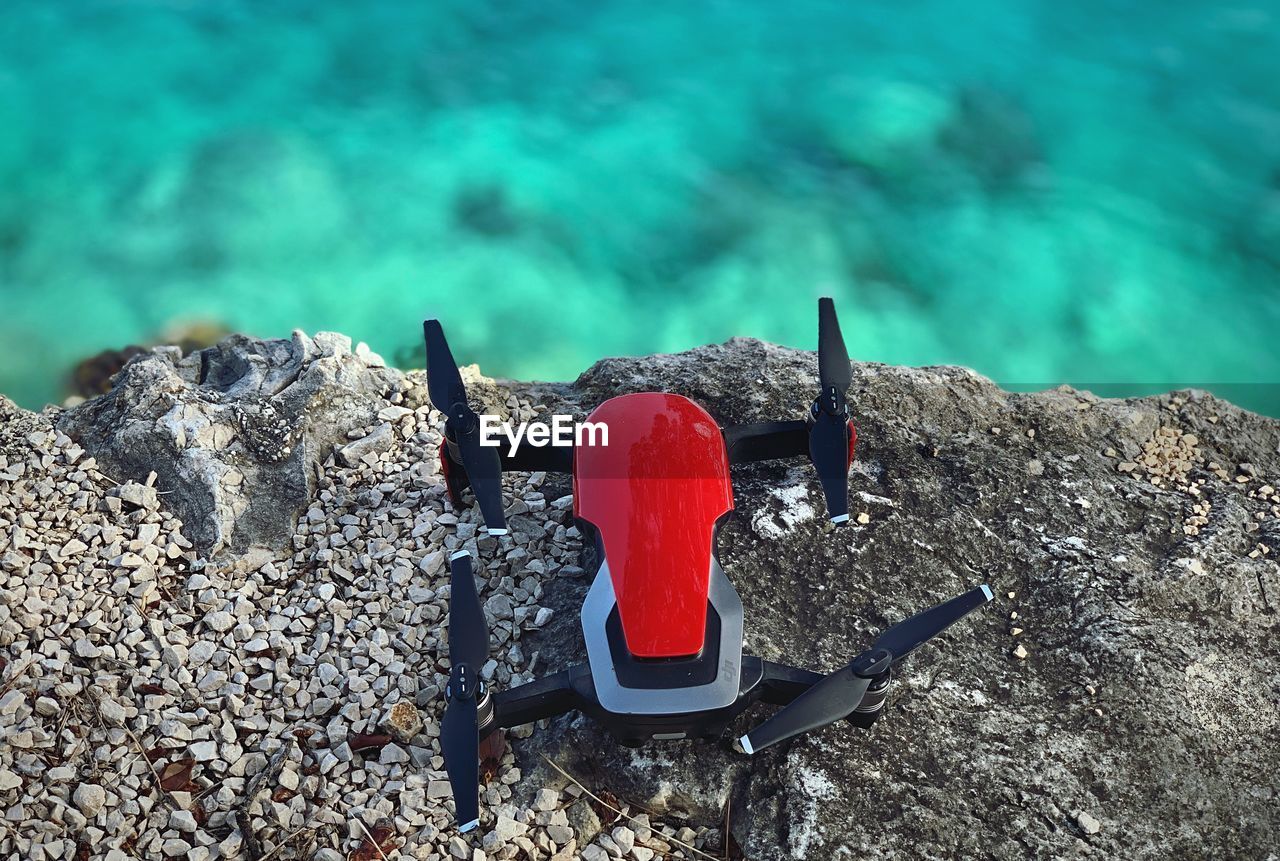 HIGH ANGLE VIEW OF RED ROCKS ON SHORE