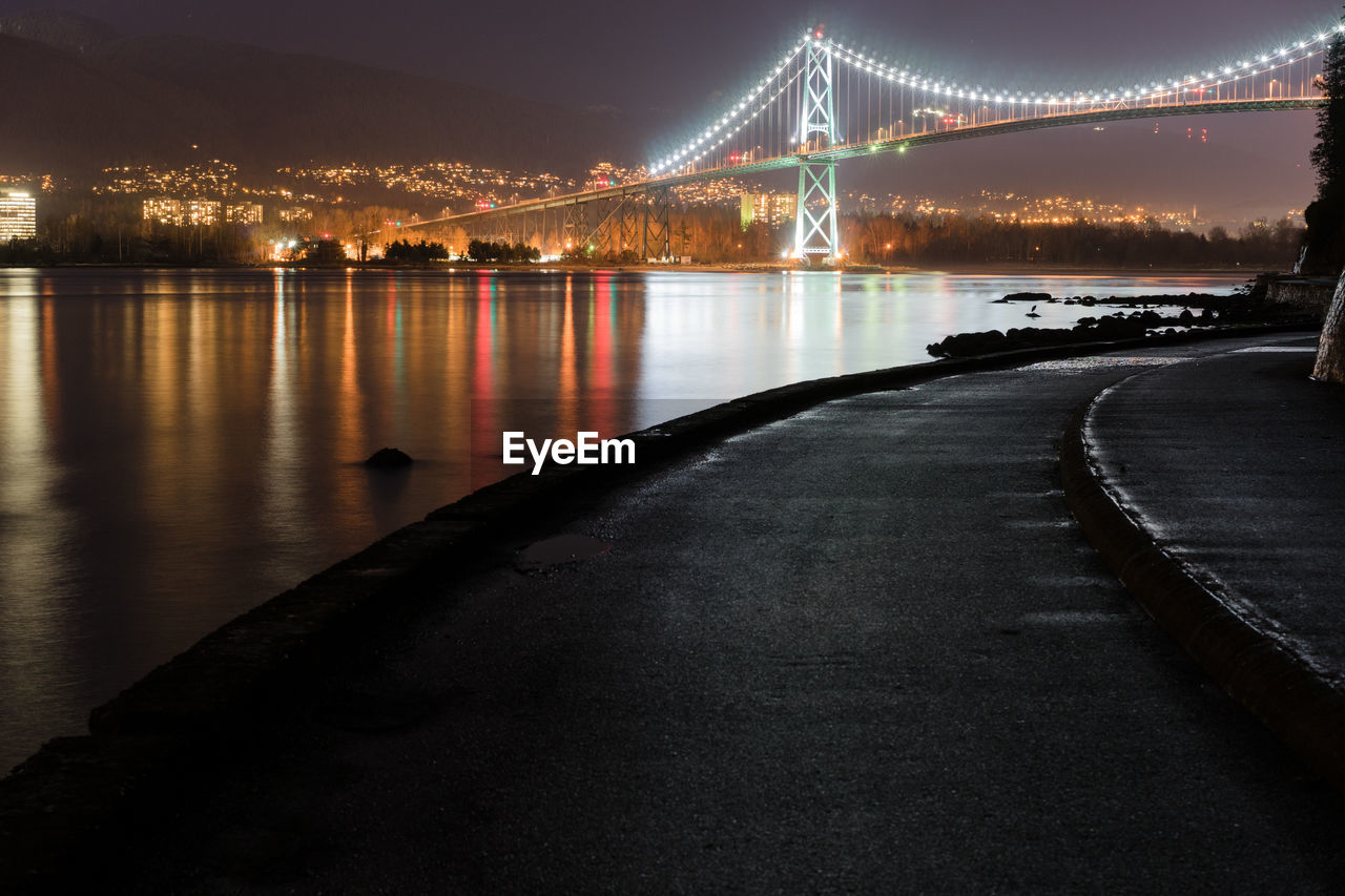 Lions gate bridge over river at night