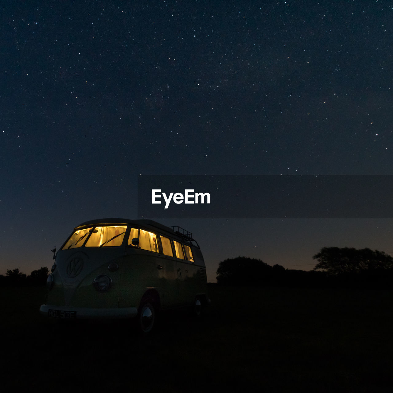 CAR ON FIELD AGAINST SKY AT NIGHT