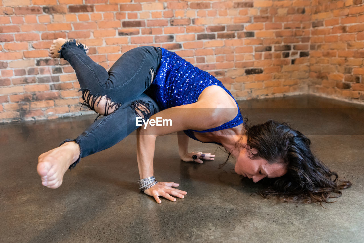 Full length of young woman against wall