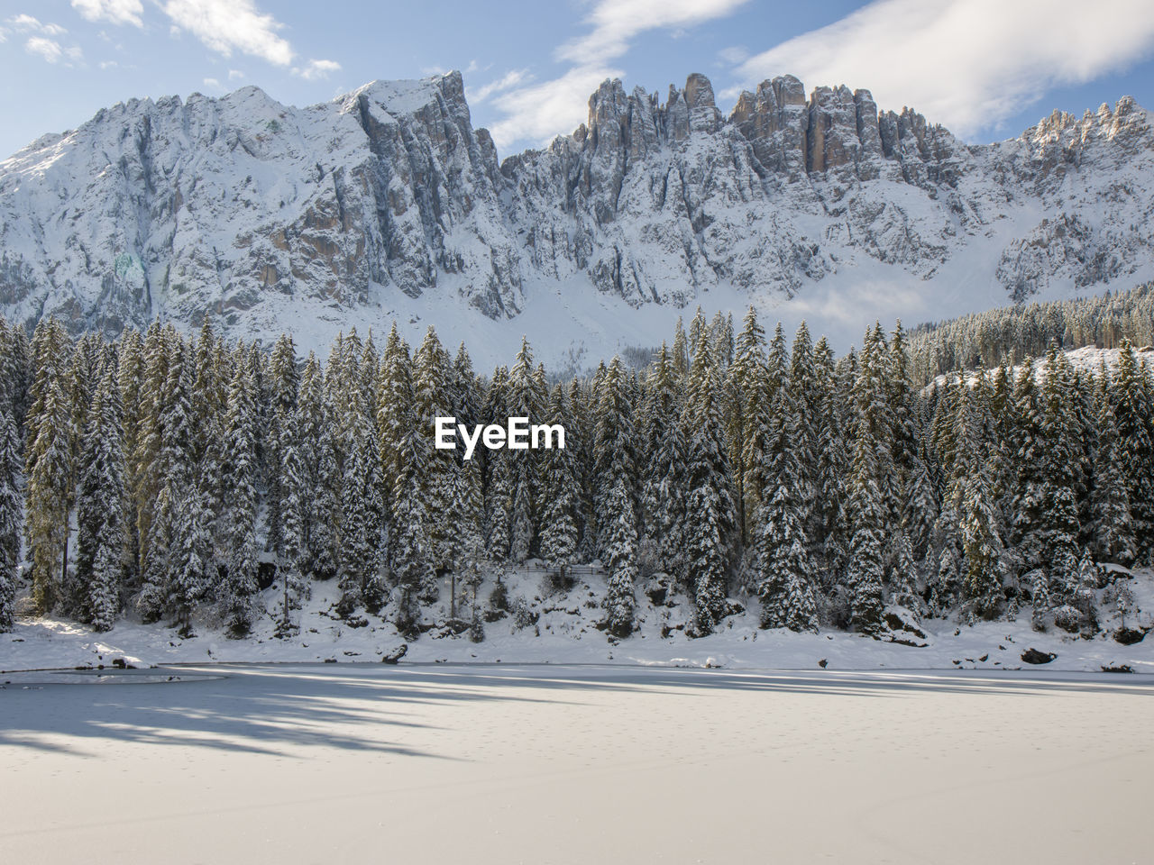 Karersee in autumn with early snow in dolomites italy