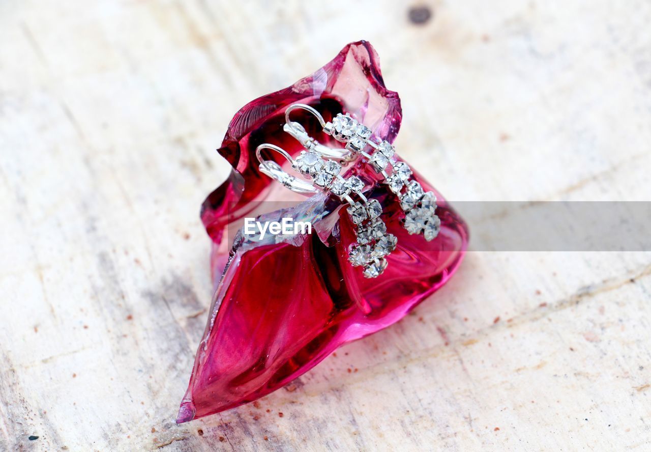 Close up of diamond earrings on red crystal