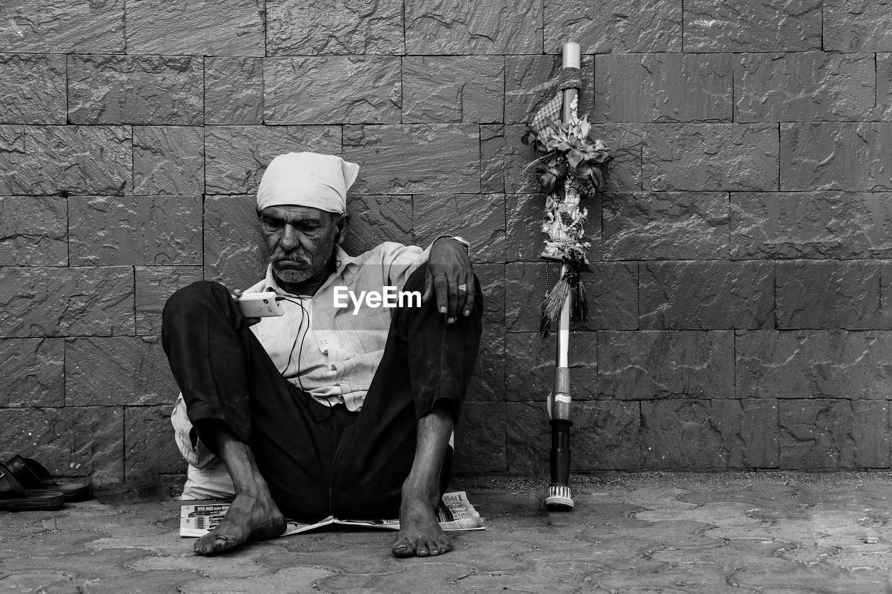 PORTRAIT OF MAN STANDING ON STONE WALL