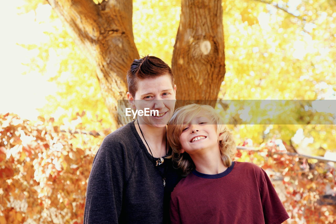 Portrait of happy mother and son in park during autumn