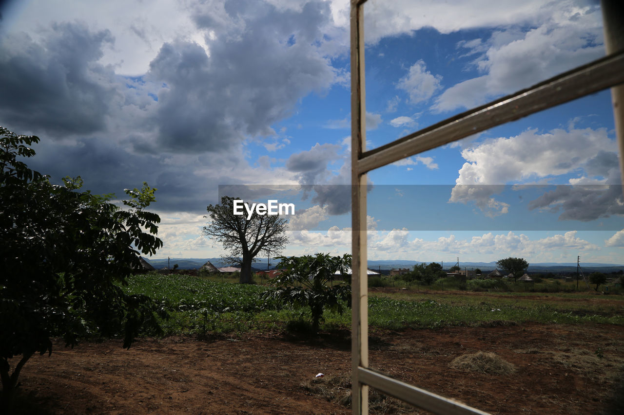 Scenic view of grassy field against cloudy sky