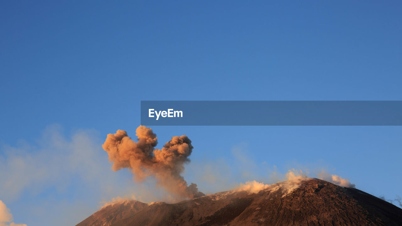 Etna volcano with smoke and ash during eruption from top crater at sunset