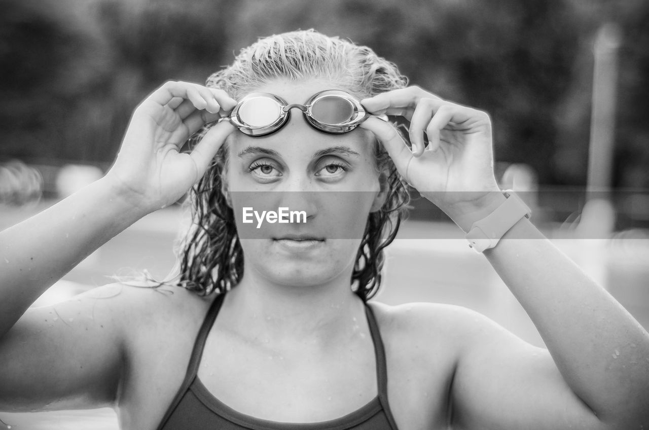 Portrait of teenage girl wearing swimming glasses in swimming pool 