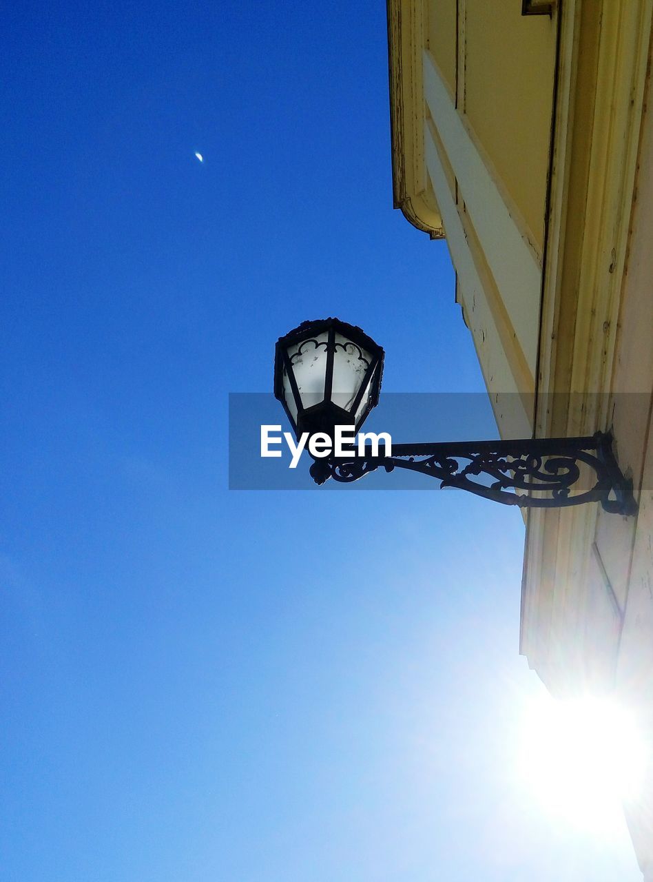 LOW ANGLE VIEW OF LIGHTING EQUIPMENT AGAINST BLUE SKY