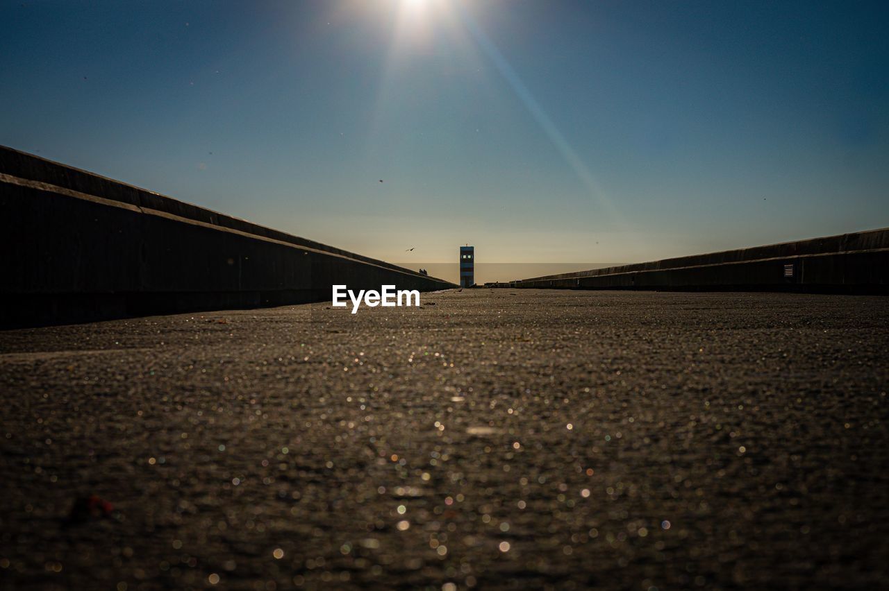 SURFACE LEVEL VIEW OF ROAD AGAINST CLEAR SKY