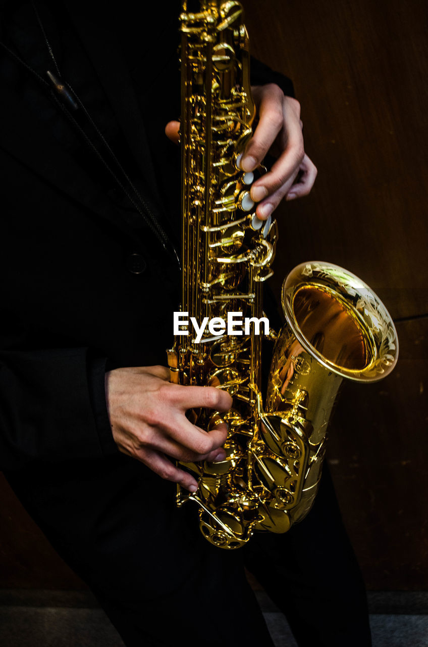 Midsection of man saxophone 