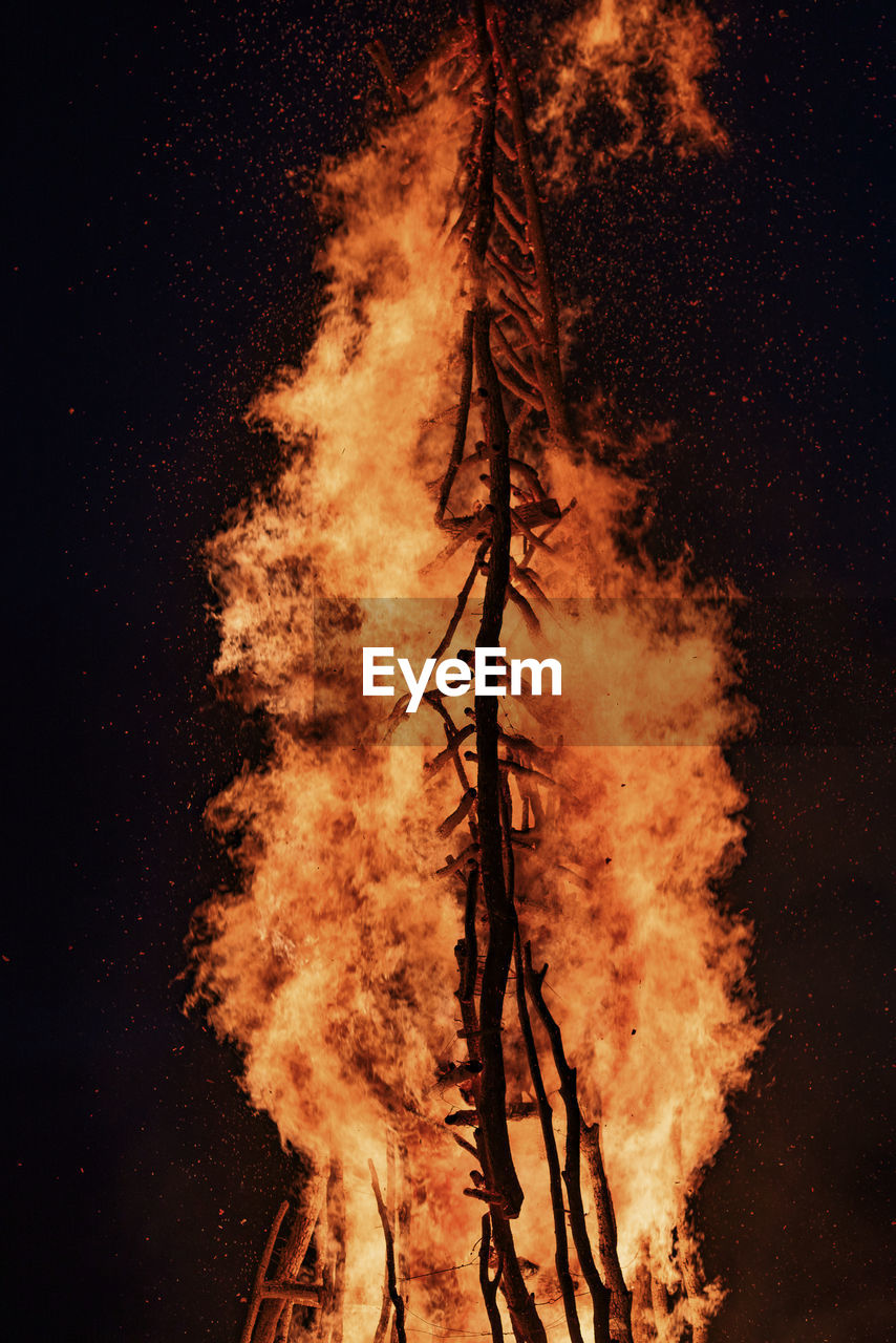 LOW ANGLE VIEW OF BONFIRE ON TREE AGAINST SKY AT NIGHT