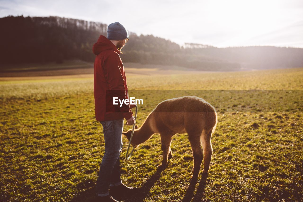 Man with animal standing on field