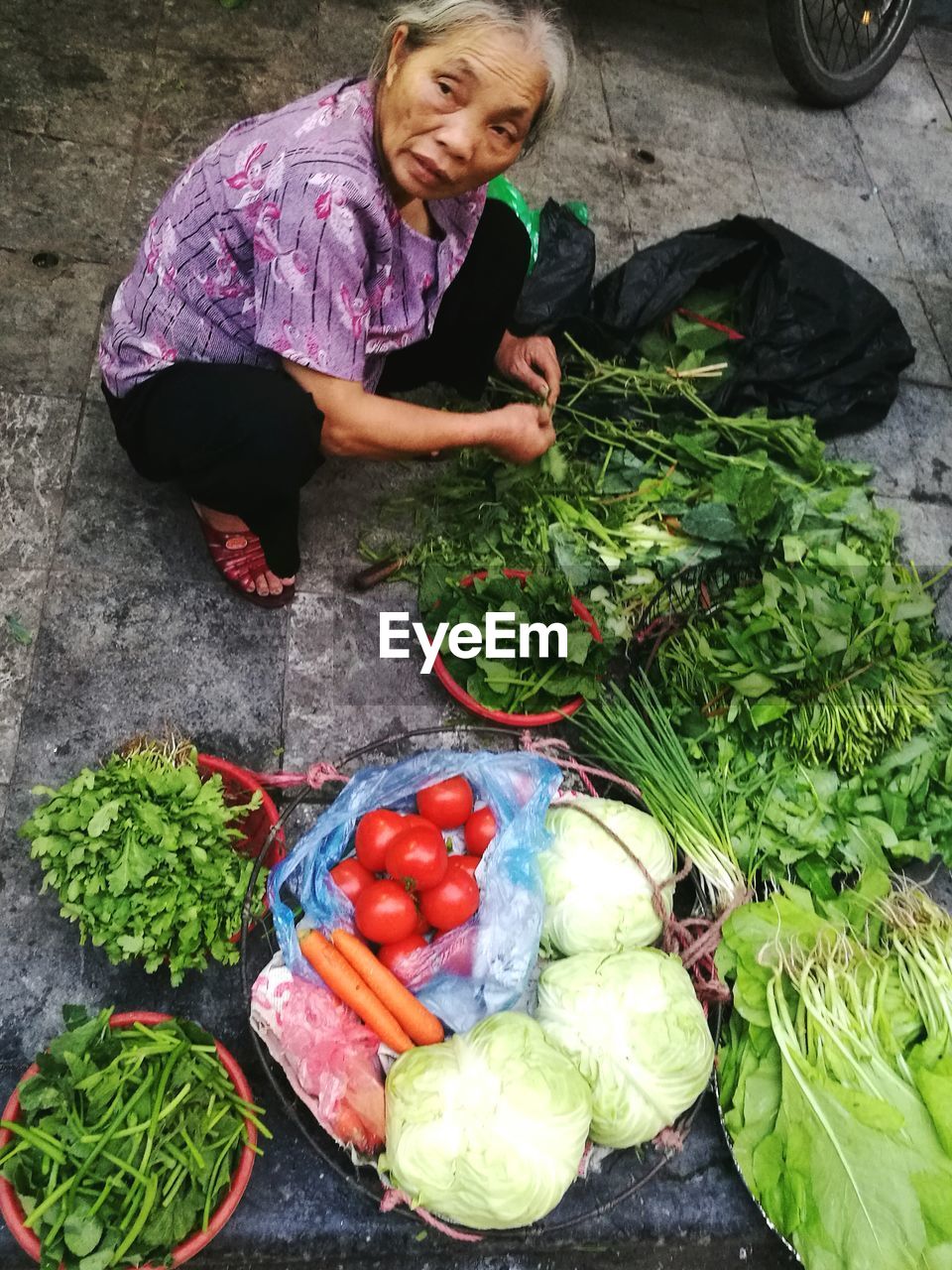 High angle view of mature woman selling vegetables at market