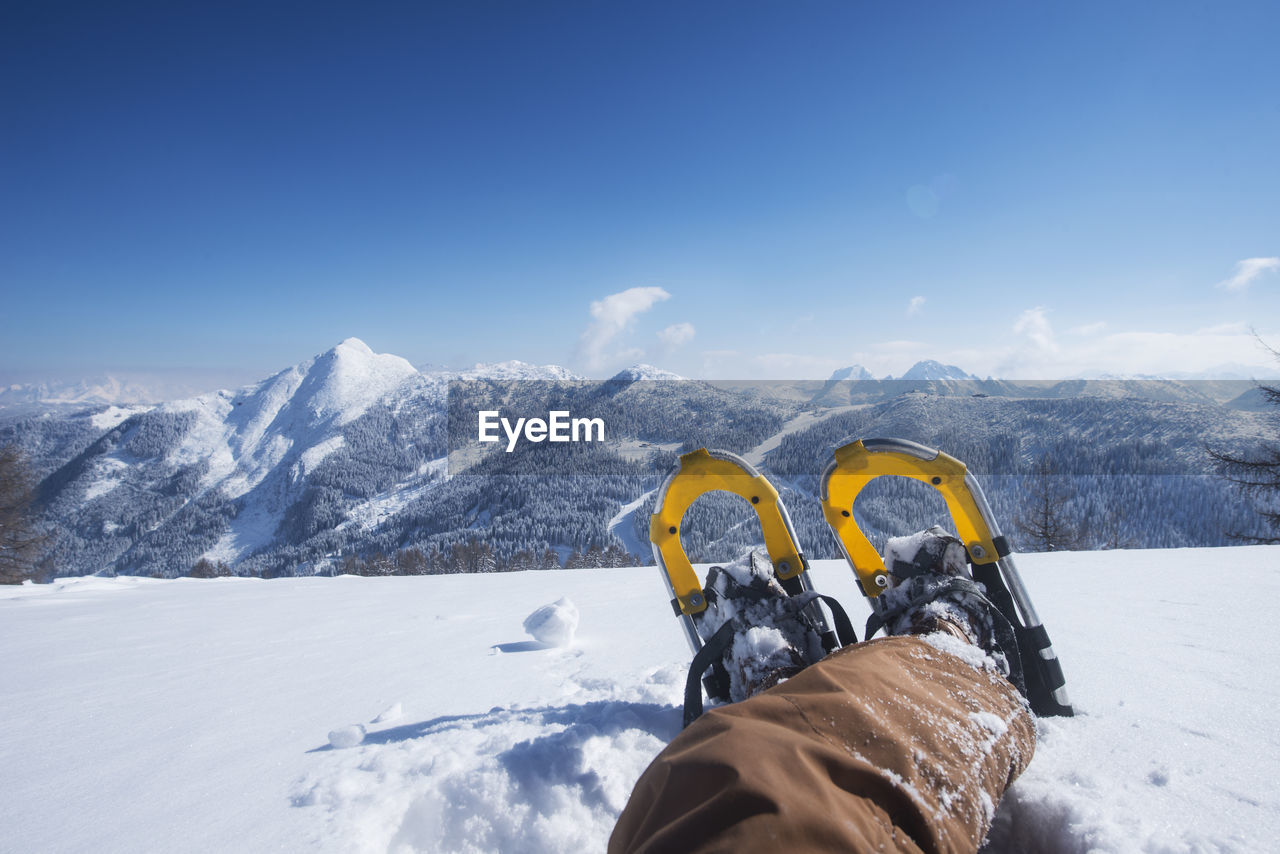 Austria, salzburg state, altenmarkt-zauchensee, man with snowshoes lying in deep snow