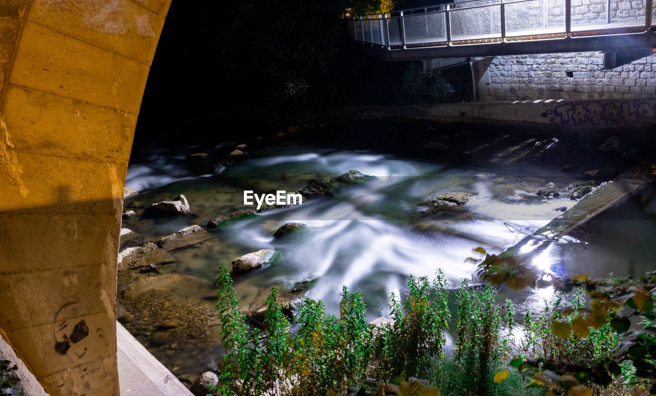 HIGH ANGLE VIEW OF WATER FLOWING FROM ROCKS