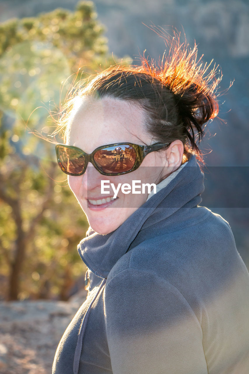 Side view portrait of smiling woman wearing sunglasses