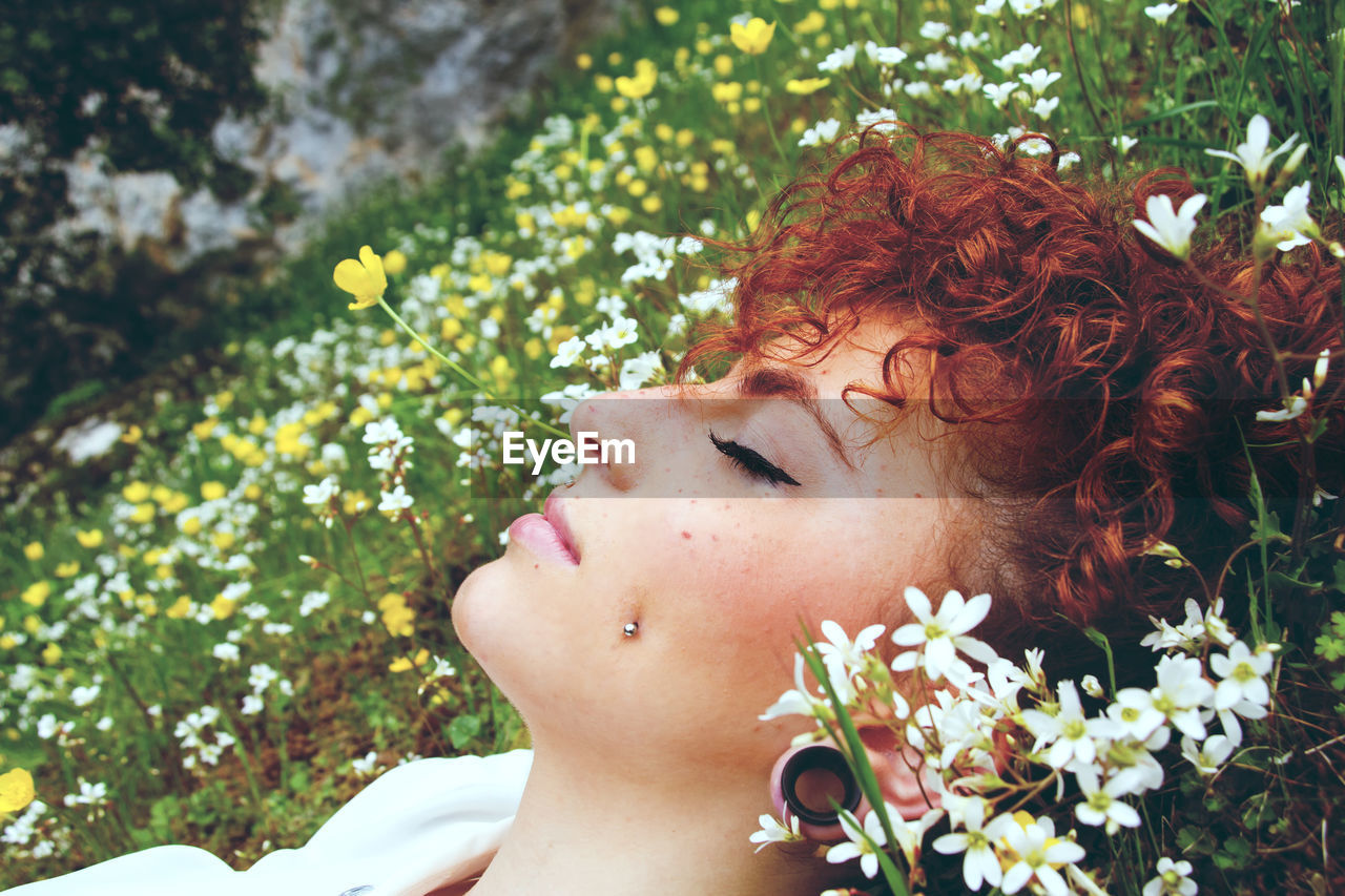 Close-up of young woman lying on field at park