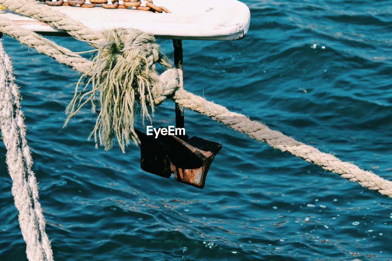 High angle view of rope tied on wooden post in sea