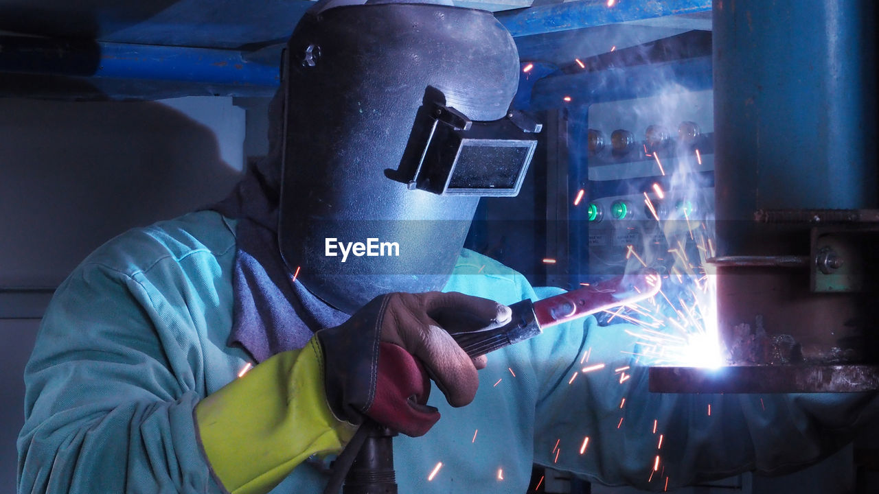 MAN WORKING IN ILLUMINATED FACTORY