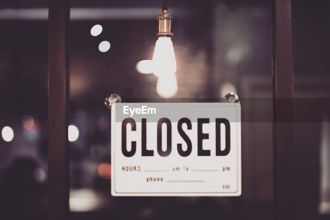 Close-up of closed sign on window