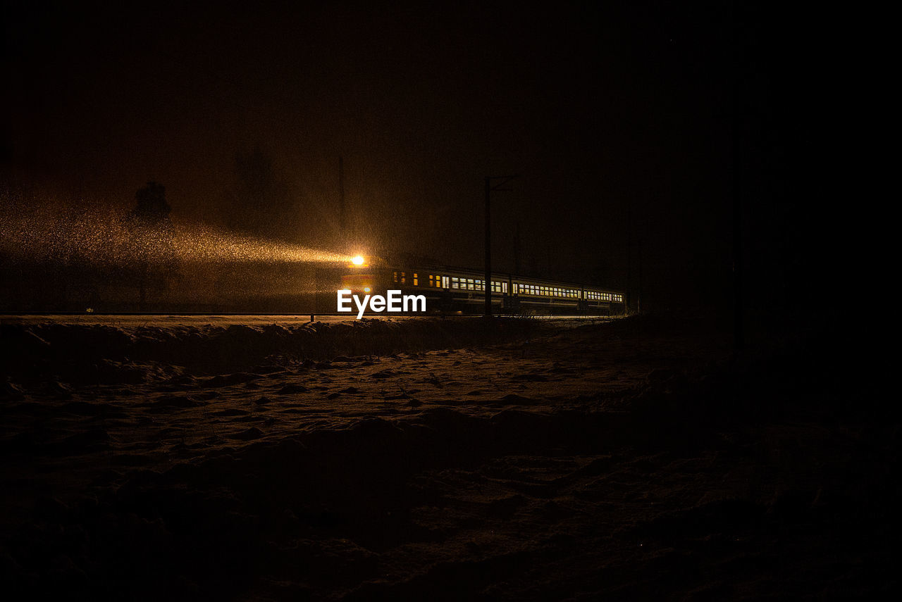 Mid distance view of illuminated train at night