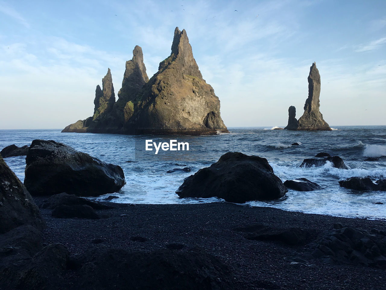 ROCK FORMATIONS ON SHORE AGAINST SKY
