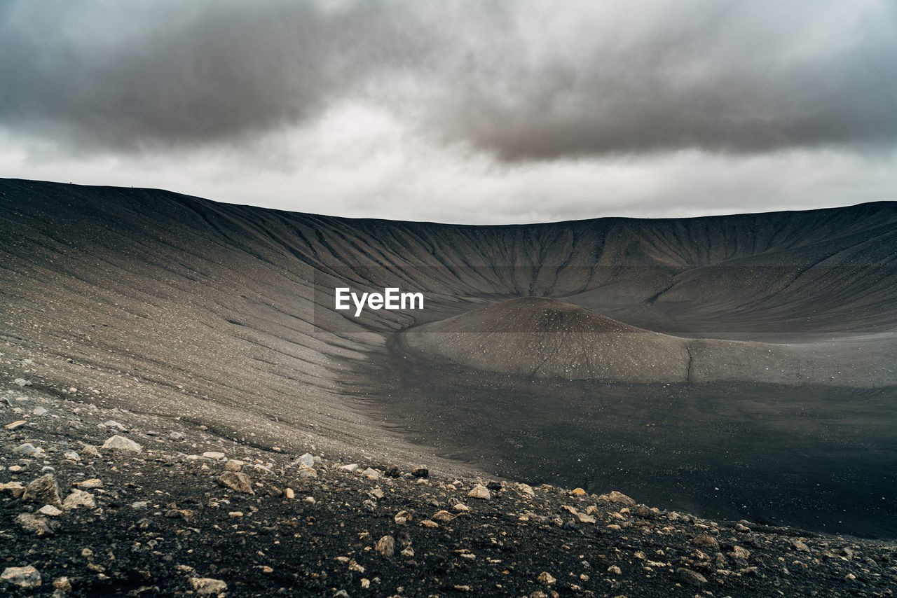 Scenic view of volcanic crater against cloudy sky